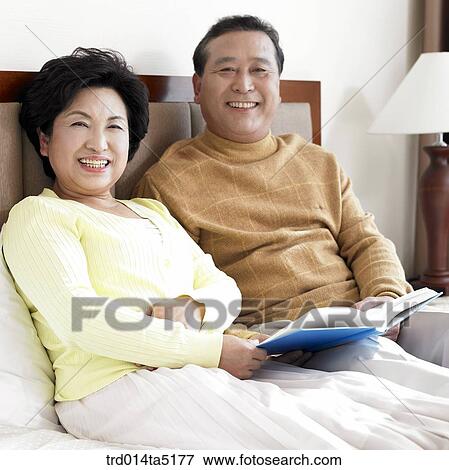 an old couple reading a book on a bed View Large Photo Image Stock Photo - an old couple reading a book on a bed. Fotosearch