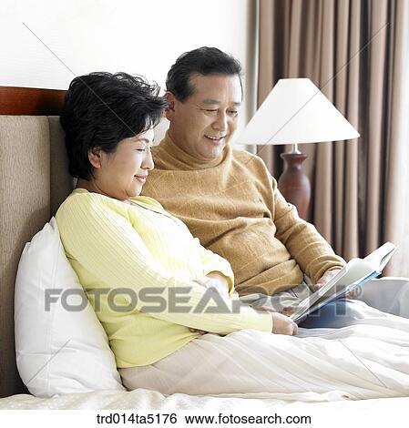 an old couple reading a book on a bed View Large Photo Image Stock Photograph - an old couple reading a book on a bed. Fotosearch