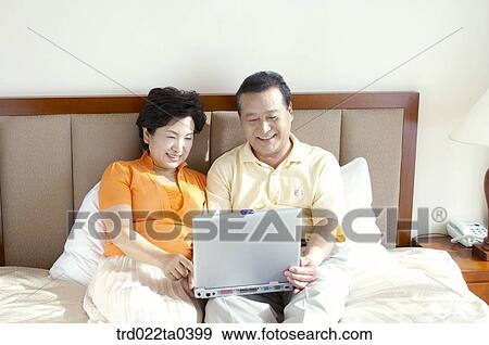 Stock Photo - an old couple using a notebook. Fotosearch