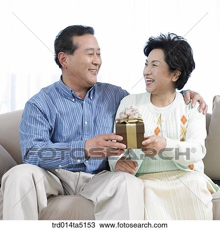 Stock Image - an old couple with a present box. Fotosearch
