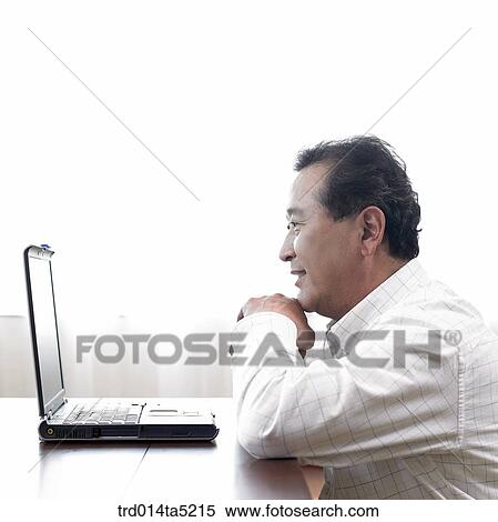 Stock Photography - an old man using a notebook. Fotosearch