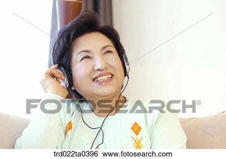 Stock Photograph - an old woman listening to music. Fotosearch