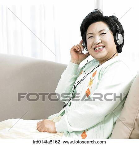 an old woman on a sofa listening to music View Large Photo Image Stock Image - an old woman on a sofa listening to music. Fotosearch