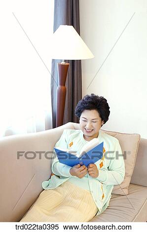 an old woman reading a book on a sofa View Large Photo Image Stock Photography - an old woman reading a book on a sofa. Fotosearch