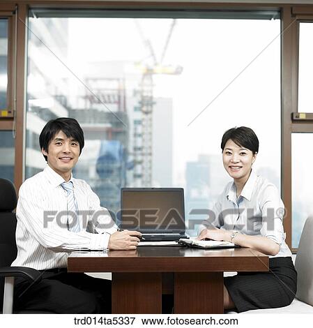 a businessman and a businesswoman by a window View Large Photo Image Stock Photo - a businessman and a businesswoman by a window. Fotosearch