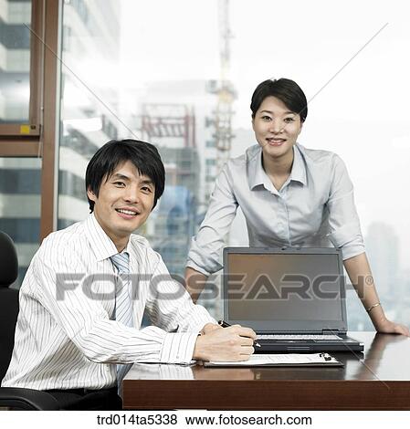 a businessman and a businesswoman looking at a document View Large Photo Image Stock Photo - a businessman and a businesswoman looking at a document. Fotosearch