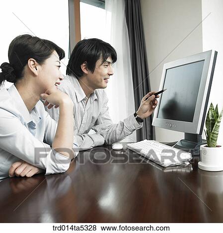 a businessman and businesswoman pointing at a monitor View Large Photo Image Stock Photo - a businessman and businesswoman pointing at a monitor. Fotosearch