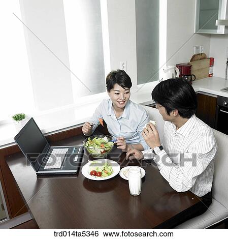 Stock Photograph - a businessman and his wife eating salads. Fotosearch