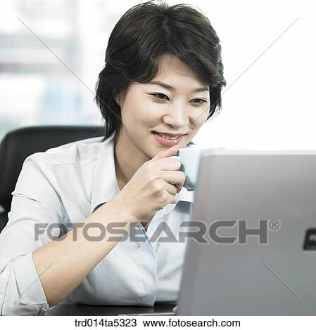 a businessman drinking a tea and looking at a notebook View Large Photo Image Stock Image - a businessman drinking a tea and looking at a notebook. Fotosearch