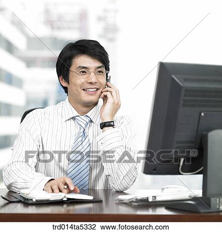 Stock Image - a businessman talking on a mobile phone. Fotosearch