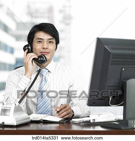 a businessman talking on a phone View Large Photo Image Stock Image - a businessman talking on a phone. Fotosearch