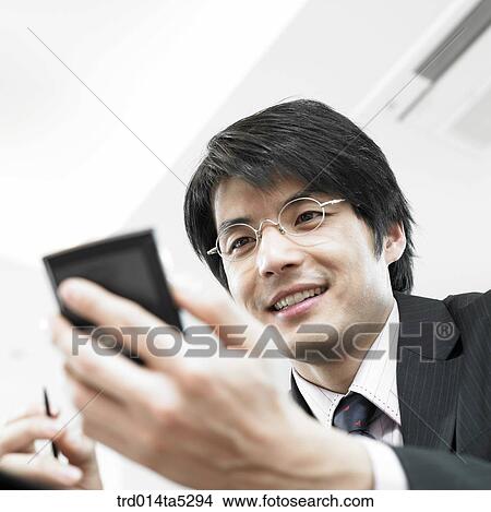 a businessman working with a PDA View Large Photo Image Picture - a businessman working with a PDA. Fotosearch