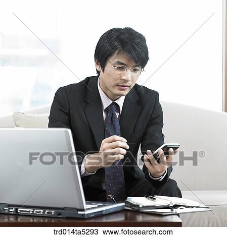 Stock Image - a businessman working with a PDA. Fotosearch