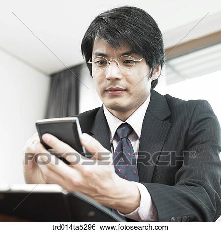 a businessman working with a PDA View Large Photo Image Stock Photograph - a businessman working with a PDA. Fotosearch