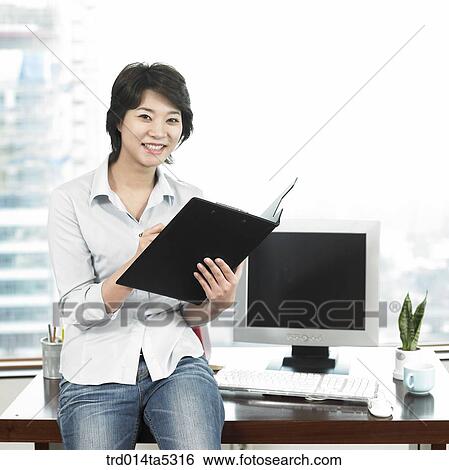 Stock Photograph - a businesswoman looking at a document. Fotosearch