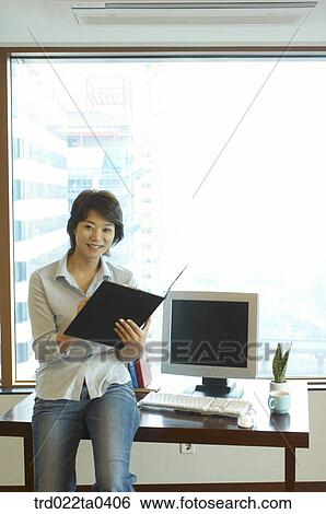 Stock Photograph - a businesswoman looking at a document. Fotosearch