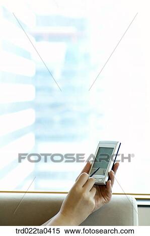Stock Photography - a hand pointing at a PDA. Fotosearch