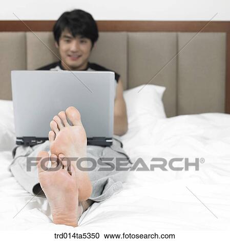 a man taking a rest on a bed View Large Photo Image Stock Image - a man taking a rest on a bed. Fotosearch