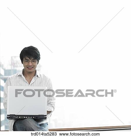Stock Image - a man working with a notebook by a window. Fotosearch