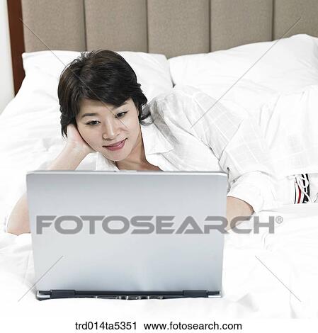 Stock Image - a woman looking at a notebook. Fotosearch