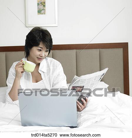 a woman reading a newspaper on a bed View Large Photo Image Stock Image - a woman reading a newspaper on a bed. Fotosearch
