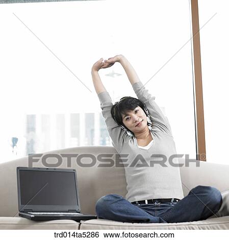 a woman straightening her back on a safa View Large Photo Image Stock Photograph - a woman straightening her back on a safa. Fotosearch