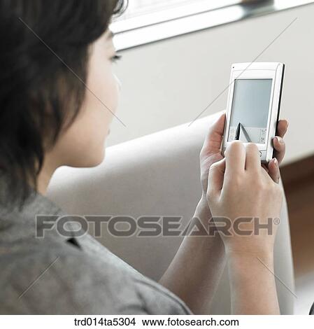 Picture - a woman's hand working with a PDA. Fotosearch