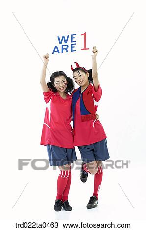 Stock Image - two cheering supporters holding a flag card. Fotosearch