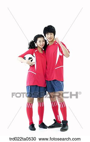 Stock Image - two supporters holding a ball. Fotosearch