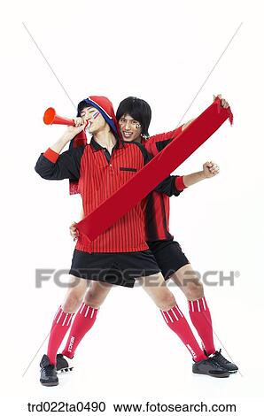 Stock Image - two supporters holding a towel and blowing a bugle. Fotosearch