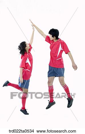 two supporters jumping and slapping high-fives View Large Photo Image Picture - two supporters jumping and slapping high-fives. Fotosearch