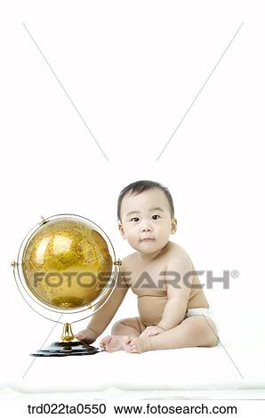 Stock Image - a baby in front of a globe. Fotosearch