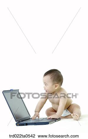 Stock Image - a baby in front of a notebook. Fotosearch
