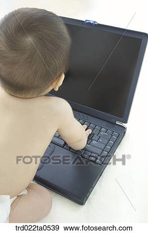 Stock Photo - a baby in front of a notebook. Fotosearch