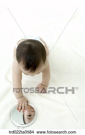 a baby looking at a mirror View Large Photo Image Picture - a baby looking at a mirror. Fotosearch