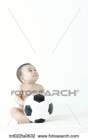 Stock Image - a baby playing a soccer ball. Fotosearch