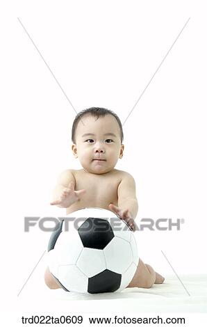 Stock Photo - a baby playing a soccer ball. Fotosearch
