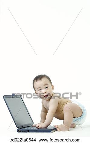 a baby playng with a notebook View Large Photo Image Picture - a baby playng with a notebook. Fotosearch