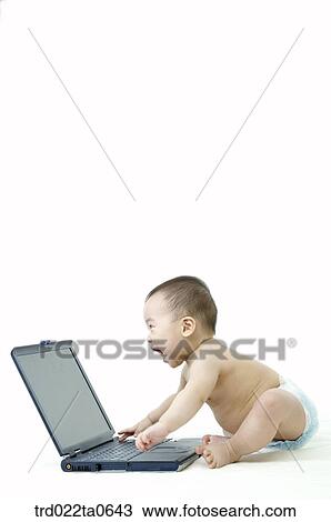 a baby playng with a notebook View Large Photo Image Stock Image - a baby playng with a notebook. Fotosearch
