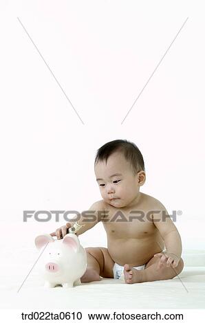 a baby putting a dollar into a pig saving box View Large Photo Image Stock Image - a baby putting a dollar into a pig saving box. Fotosearch