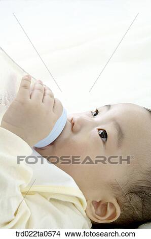 a baby sucking a nursing bottle View Large Photo Image Picture - a baby sucking a nursing bottle. Fotosearch