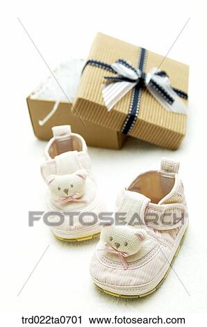 Stock Image - baby supplies/a baby shoe and a present box. Fotosearch