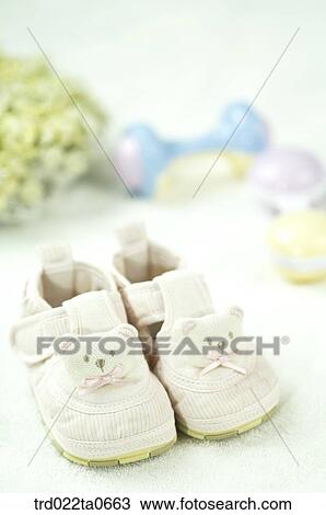 Stock Image - baby supplies/a baby shoe and a noisemaker. Fotosearch