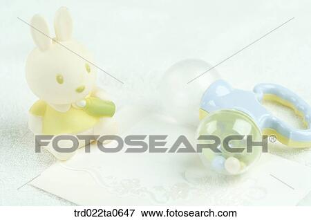 Stock Photo - baby supplies/a noisemaker and a rabbit doll. Fotosearch