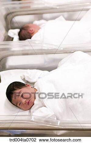 Stock Image - lying newborn babies in a bed. Fotosearch