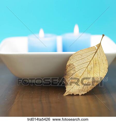 Stock Photograph - a candle and a fallen leaf. Fotosearch
