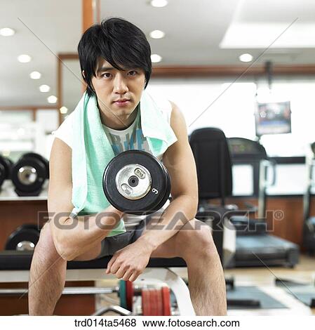 a man exercising with dumbbells at a fitness club View Large Photo Image Stock Photo - a man exercising with dumbbells at a fitness club. Fotosearch