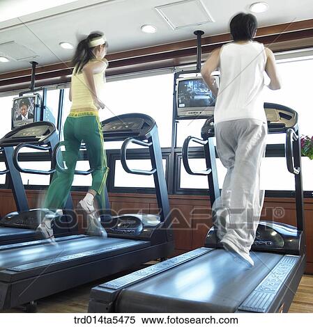 a running couple on a running machine at a fitness club View Large Photo Image Stock Photography - a running couple on a running machine at a fitness club. Fotosearch
