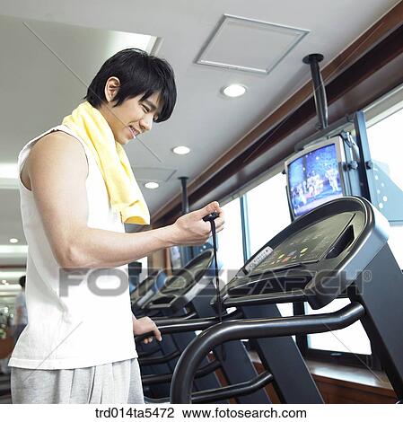 Stock Image - a running man on a running machine at a fitness club. Fotosearch