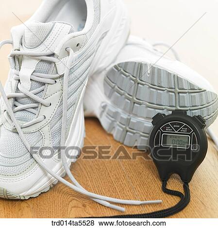 Stock Photo - a running shoe and a stopwatch. Fotosearch